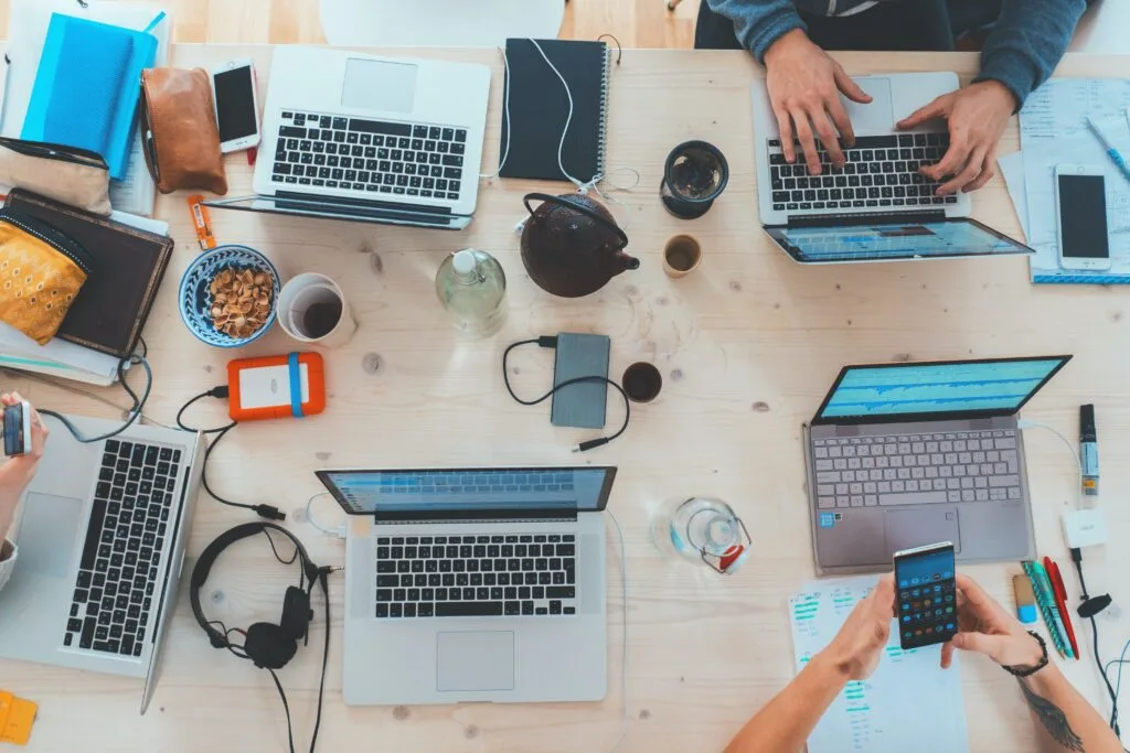 Groupe de travail autour d'une table avec les ordinateurs